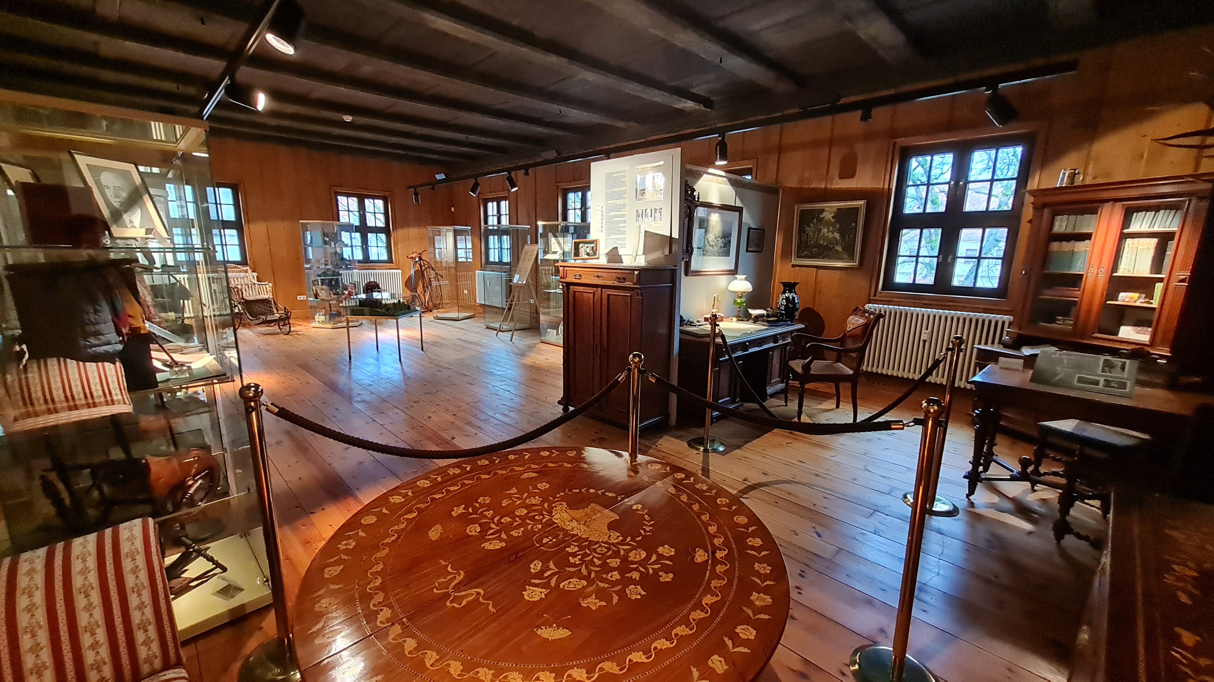 Museumsbereich mit Stubenrauchzimmer. Ein holzverkleideter Raum mit historischen Möbeln und Vitrinen.