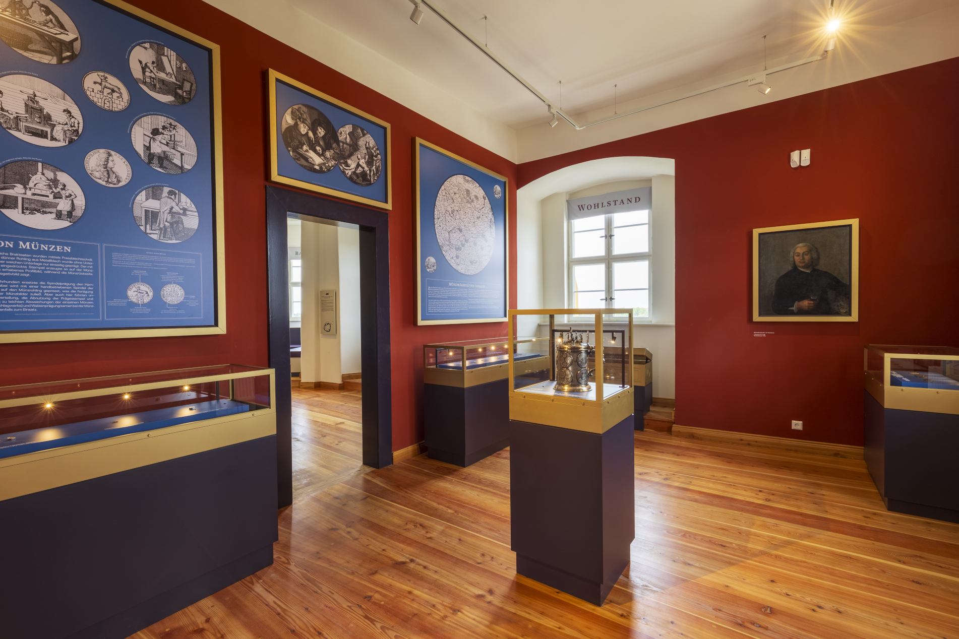 Münzkabinett. Hier werden wertvolle Münzen in Vitrinen an den Wänden präsentiert. Informationstafeln informieren über die Herstellung und geschichtliche Hintergründe. In der Mitte steht die Lehmerscher Bergkanne auf einem Sockel.