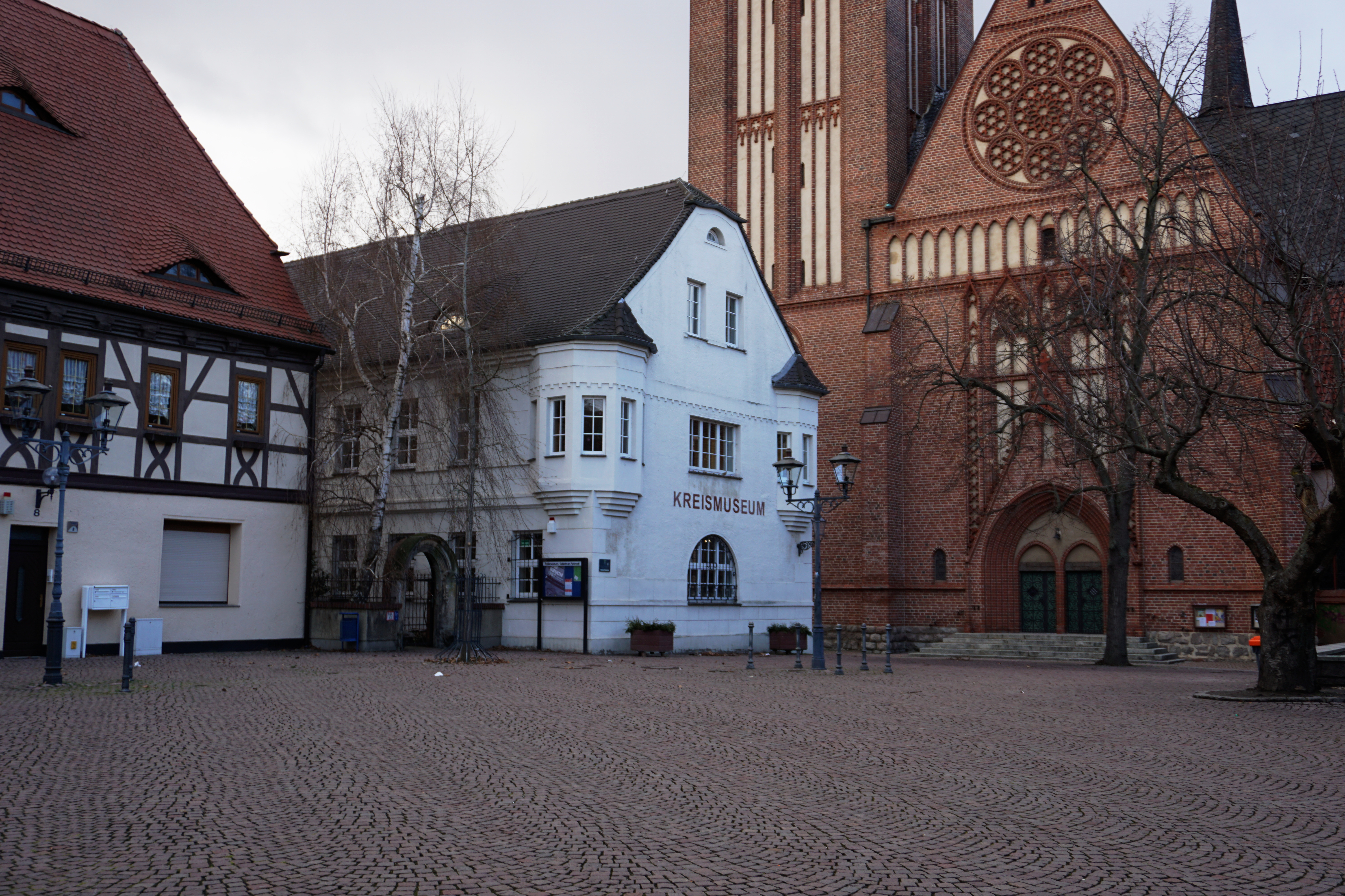 Das Kreismuseum Bitterfeld neben einer roten Backsteinkirche.