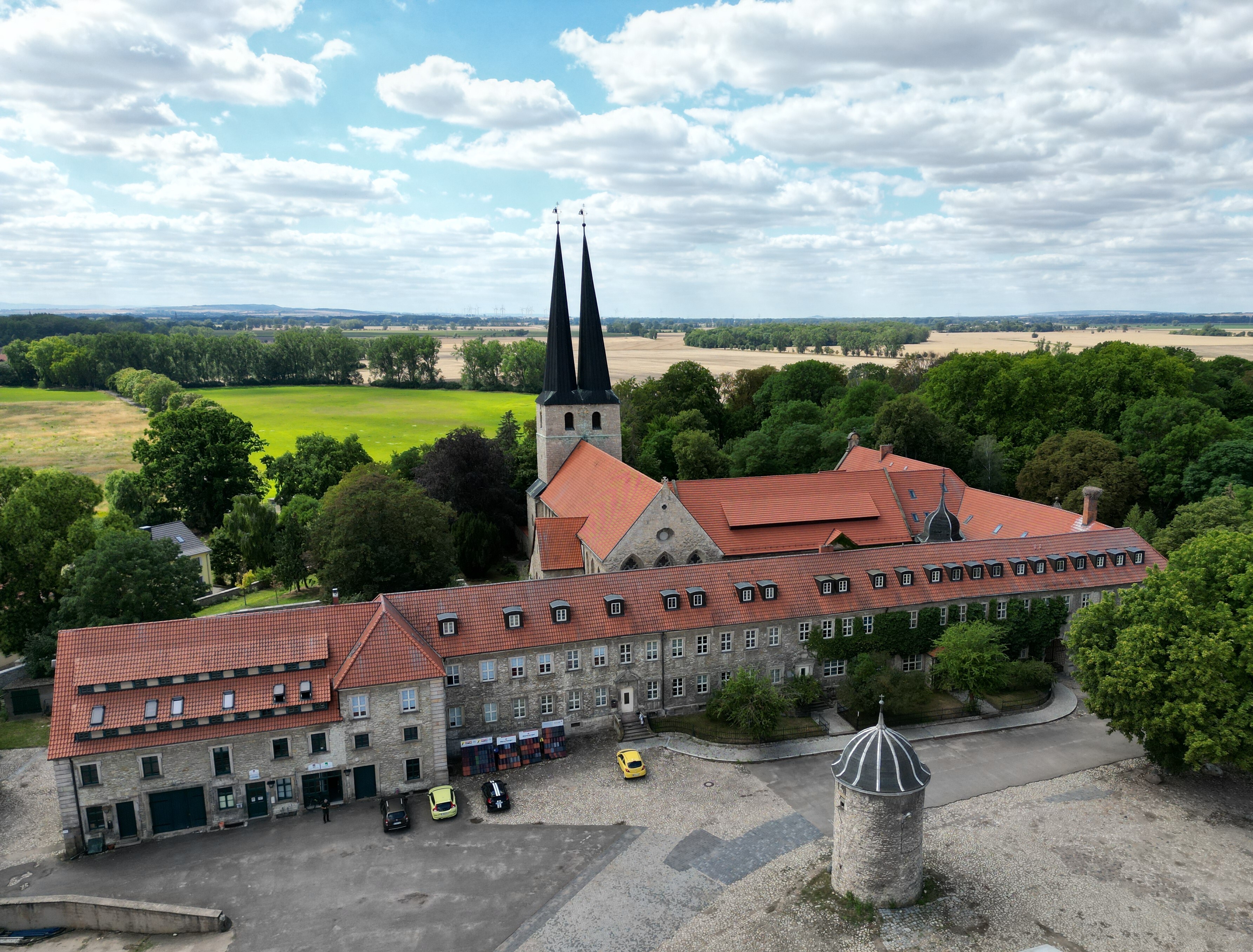 Auf einer Luftaufnahme ist die Klosteranlage erkennbar. Zwei spitze Türme der Pfarrkirche ragen zwischen den Dächern empor. Ein kleiner Turm steht vor dem Klosterkomplex.