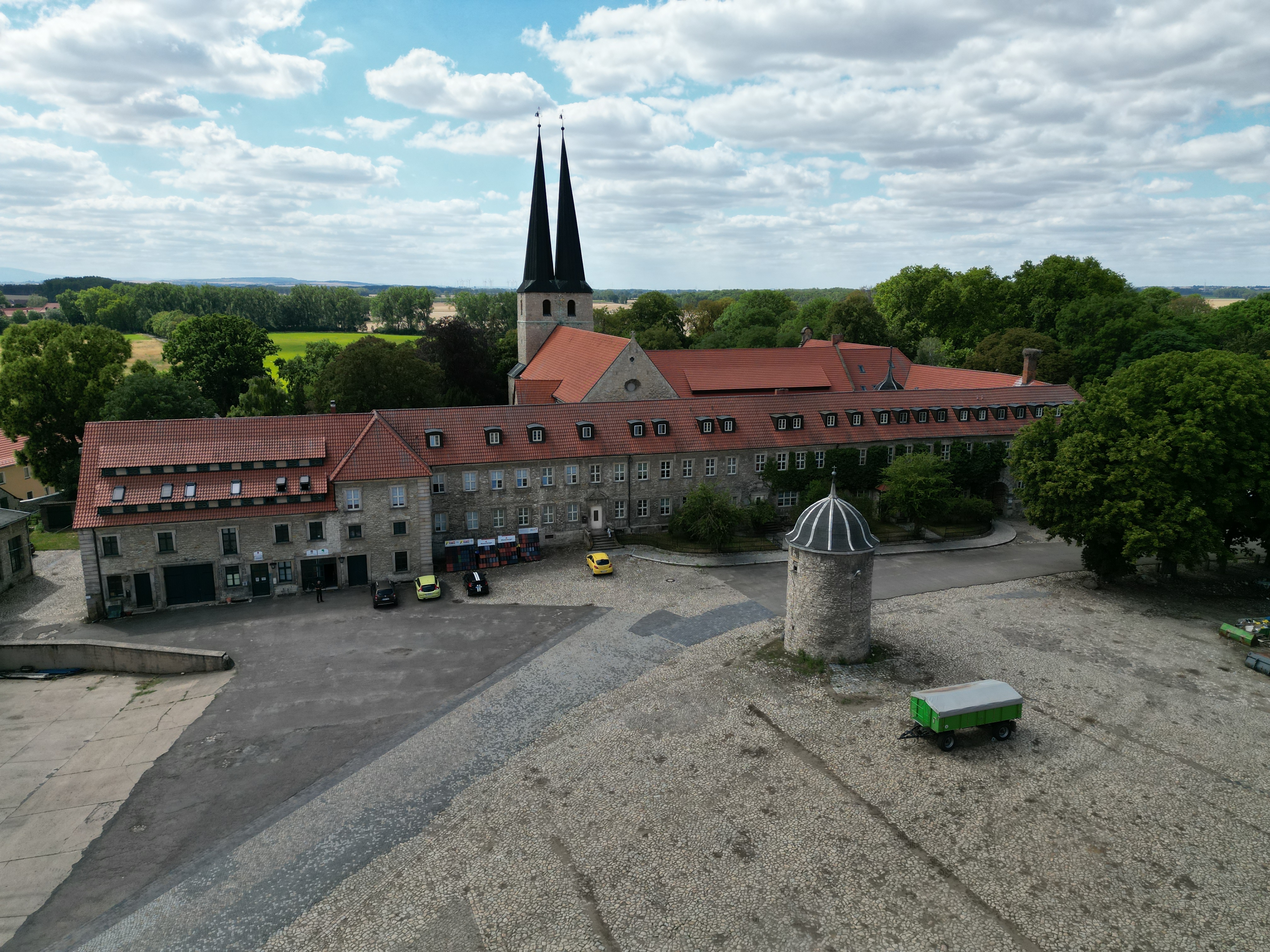 Auf einer Luftaufnahme ist die Klosteranlage erkennbar. Zwei spitze Türme der Pfarrkirche ragen zwischen den Dächern empor. Ein kleiner Turm steht vor dem Klosterkomplex.