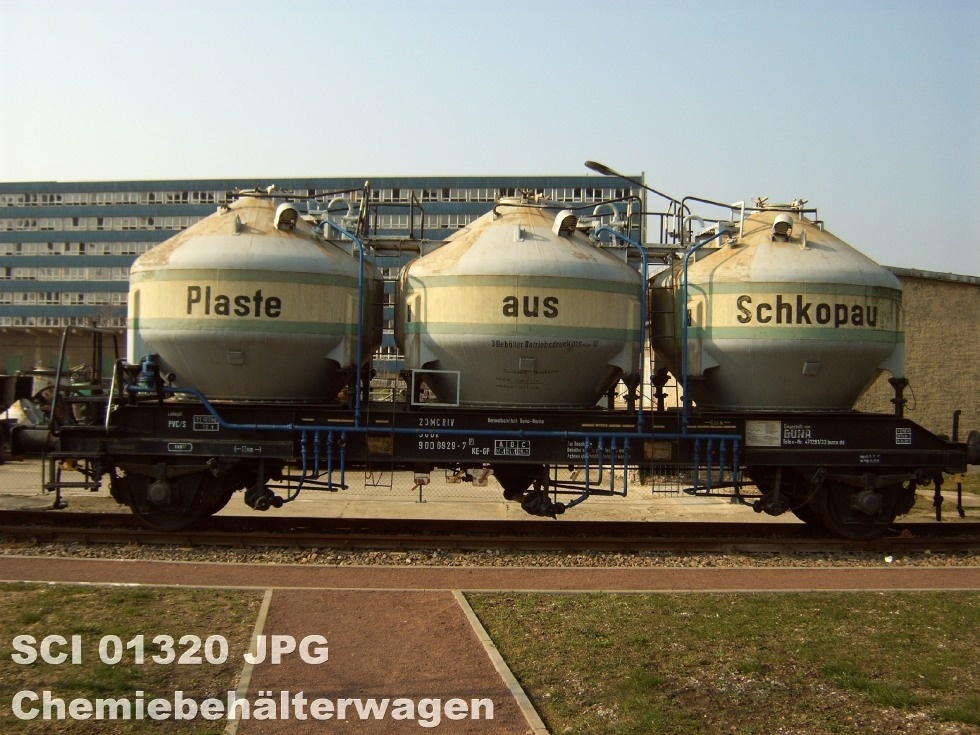 Ein Wagen mit drei großen Behältern steht auf einem Platz. Auf den Behältern befindet sich der Schriftzug: Plaste aus Schkopau.