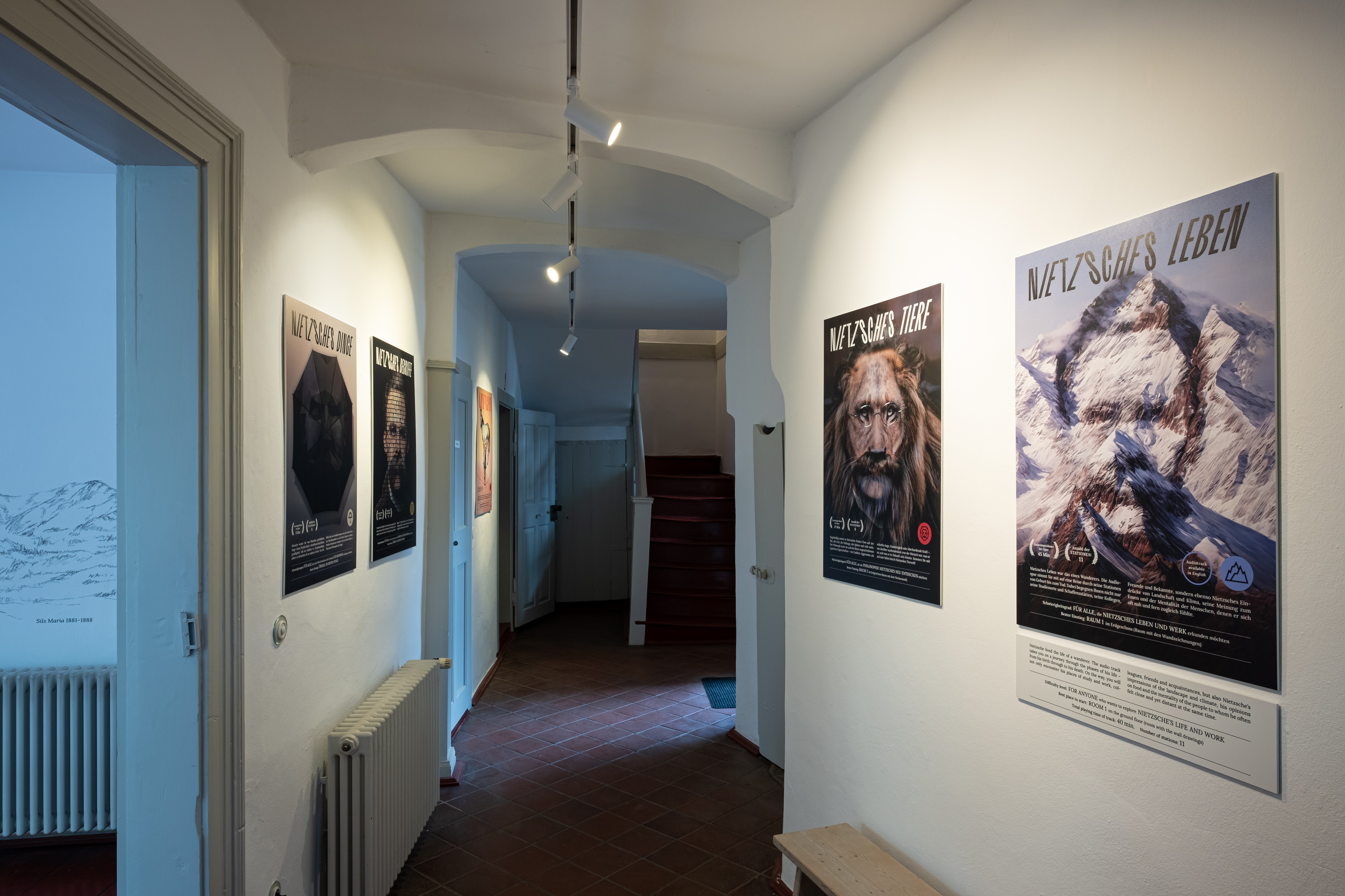 Im Durchgangsflur hängen verschiedene Plakate, die das Gesicht von Friedrich Nietzsche zeigen.
