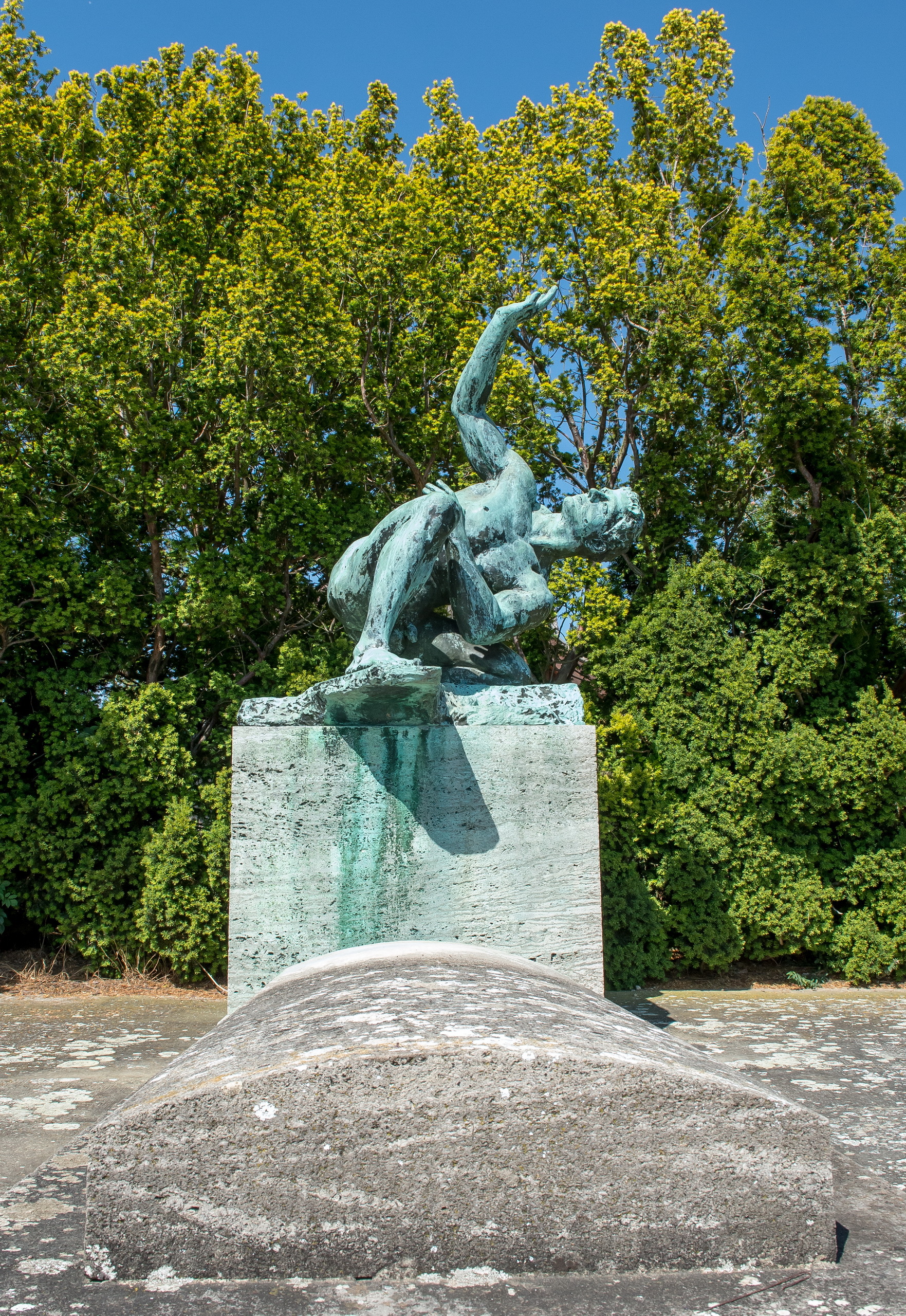 Die Grabanlage Max Klingers besteht aus einer grauen Betonplatte. Die Bronzeplastik "Athlet" kniet darüber.