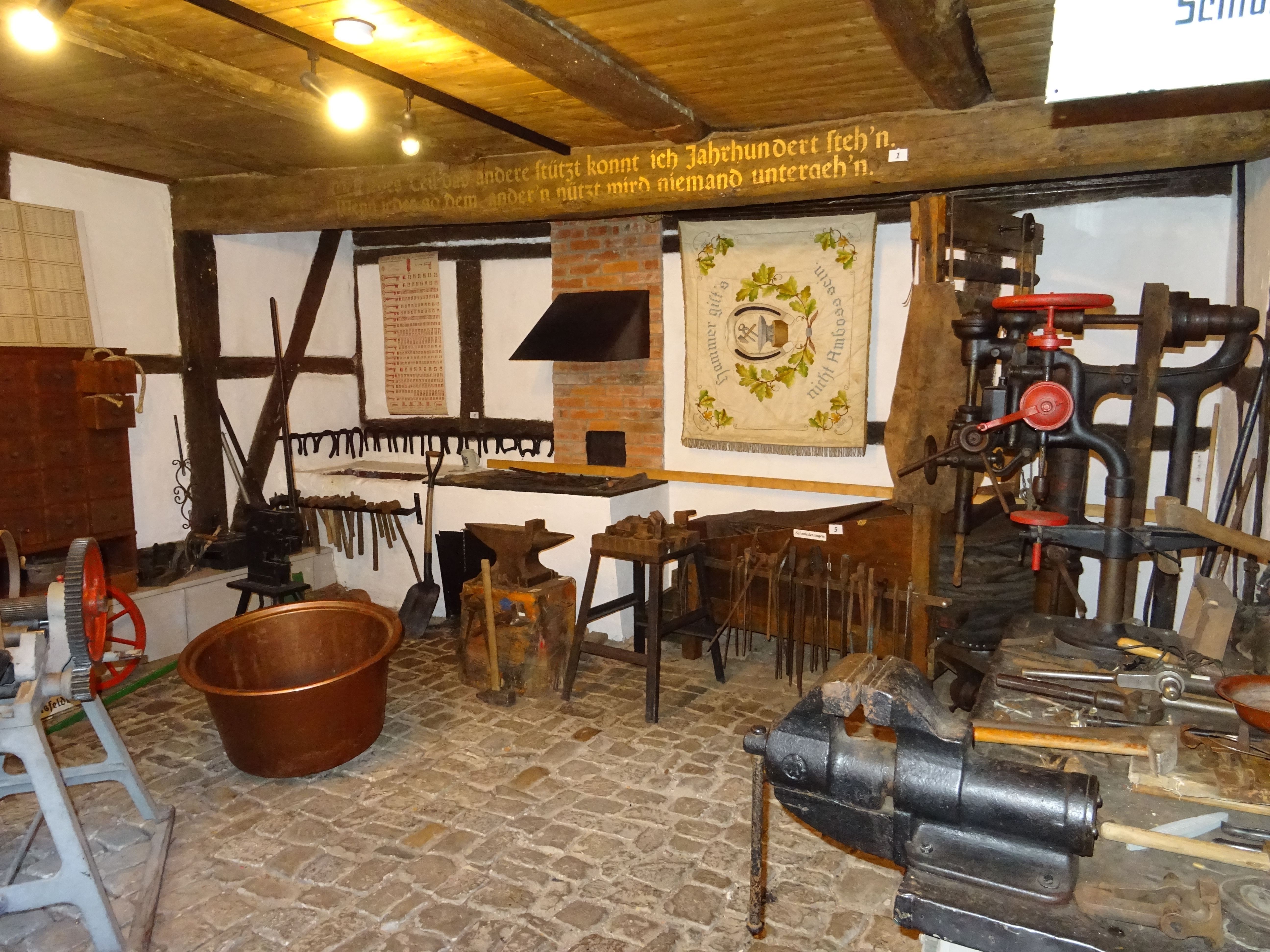 In der Schmiede werden handwerkliche Geräte präsentiert. Neben Schraubstöcken und anderen Werkzeugen werden auch die Schmiedeutensilien gezeigt.