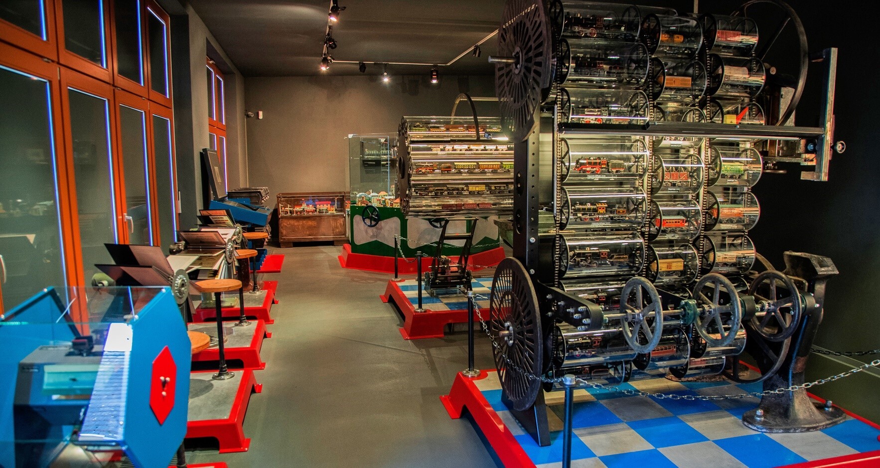 Blick in die Ausstellung "Die Geschichte der Blechspielwarenfabrik Josef Kraus und Co in Nürnberg". In der Ausstellung werden Blechspielzeuge gezeigt, die in besonderer Präsentationsform mittels mechanischer Vorrichtungen platziert wurden.