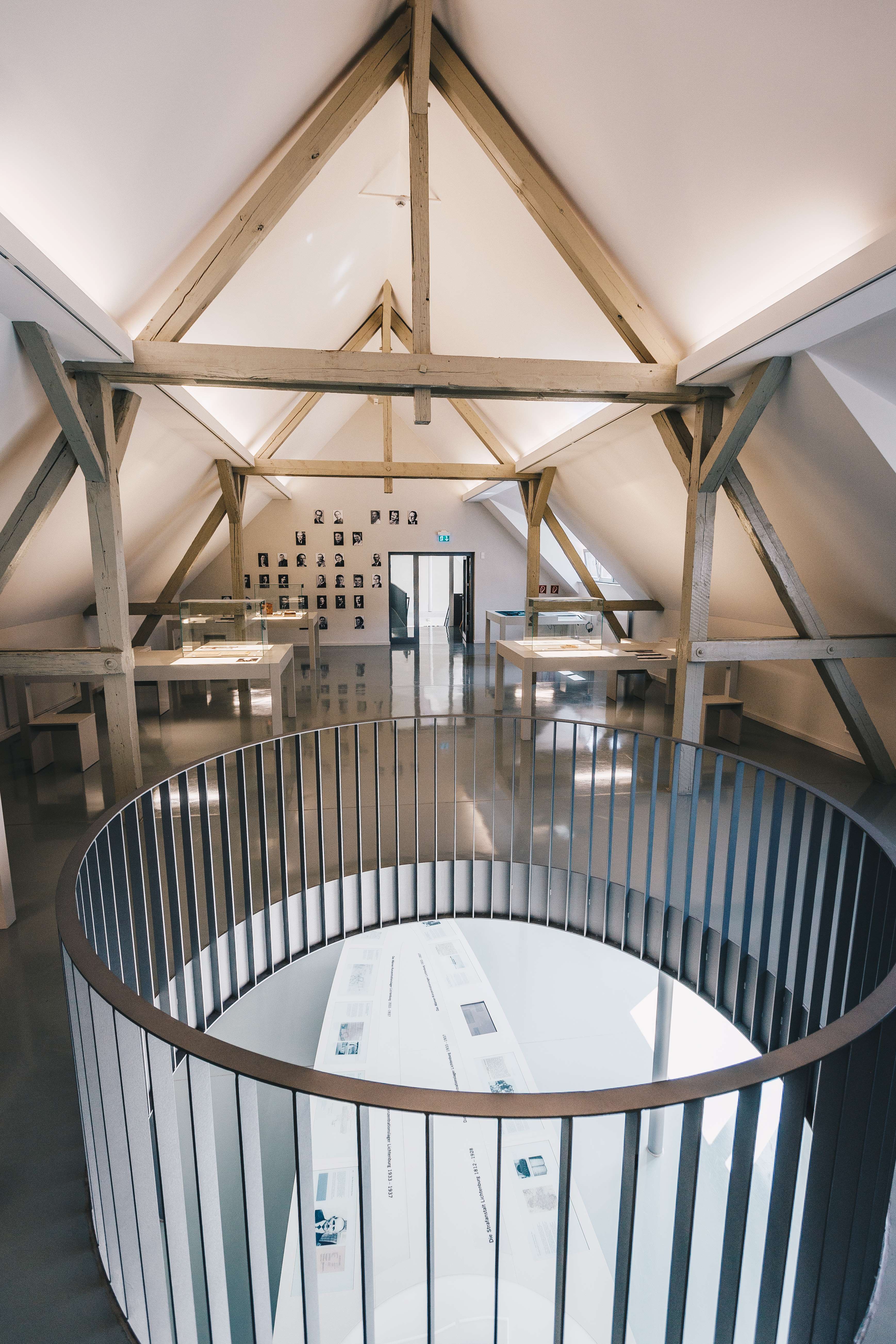Die Dauerausstellung befindet sich im Dachgeschoss, das durch Holzbalken gestützt wird. Ein runder Durchbruch im Boden lässt einen Blick auf die Ausstellung im unteren Geschoss zu.